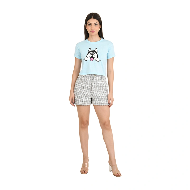 Female model in sky blue crop top with cartoon husky print and grey tweed shorts - fashion ecommerce photography by Lohar Studio Delhi